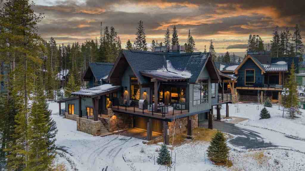 Elegant mountain chalet with large balcony and snow-covered surroundings.