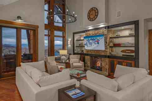 Luxurious living room with mountain views, modern fireplace, and elegant decor.