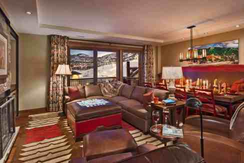Luxurious living room with mountain view, cozy seating, and warm lighting.