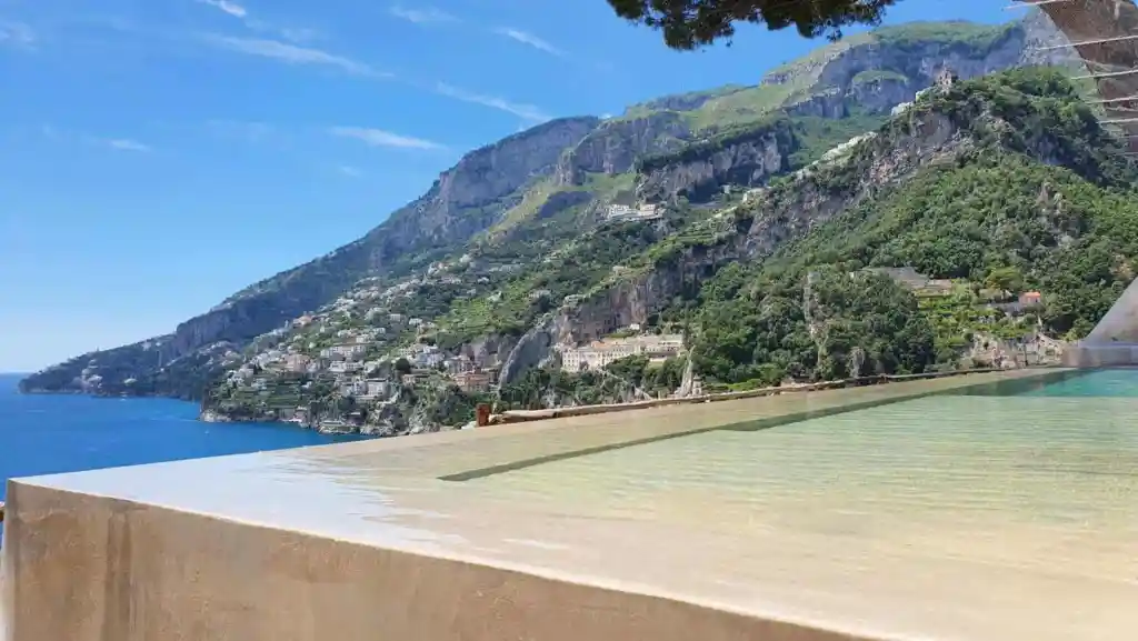 Beautiful view of the Amalfi Coast with mountains and sea from a poolside perspective.