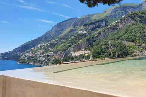 Beautiful view of the Amalfi Coast with mountains and sea from a poolside perspective.