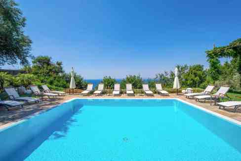 Serene outdoor swimming pool with lounge chairs and umbrellas.