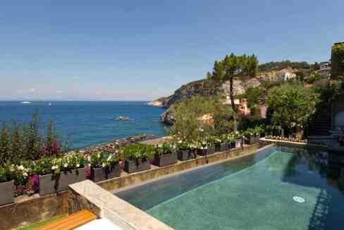 Seaside infinity pool overlooking Amalfi Coast with scenic ocean view.