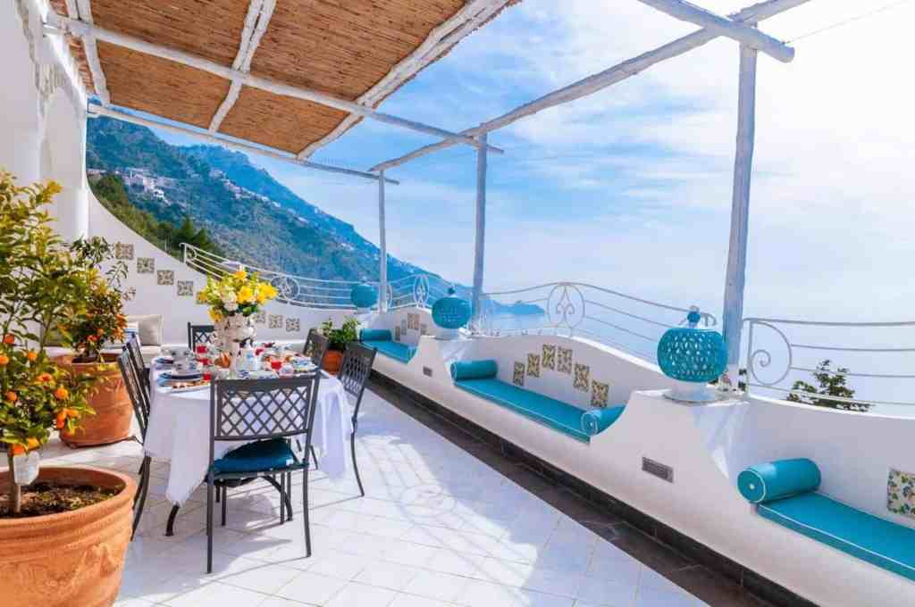 Beautiful coastal terrace with sea view, outdoor dining, and relaxing seating area.