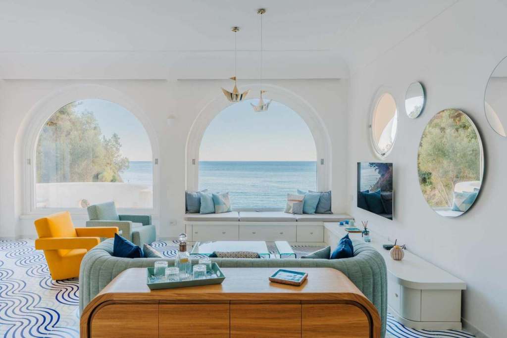 Bright living room with ocean view, modern decor, and large windows.