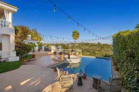 Elegant pool area at Stradella Beverly Villa with outdoor seating and string lights.