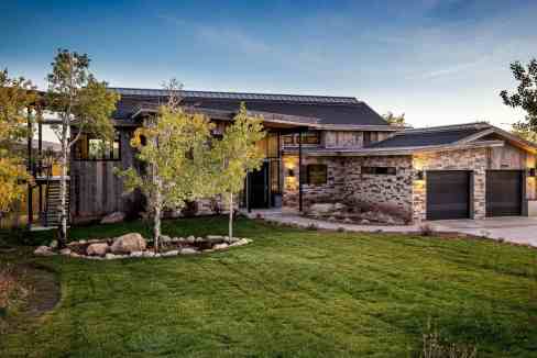 Contemporary house with landscaped garden and driveway at sunset.