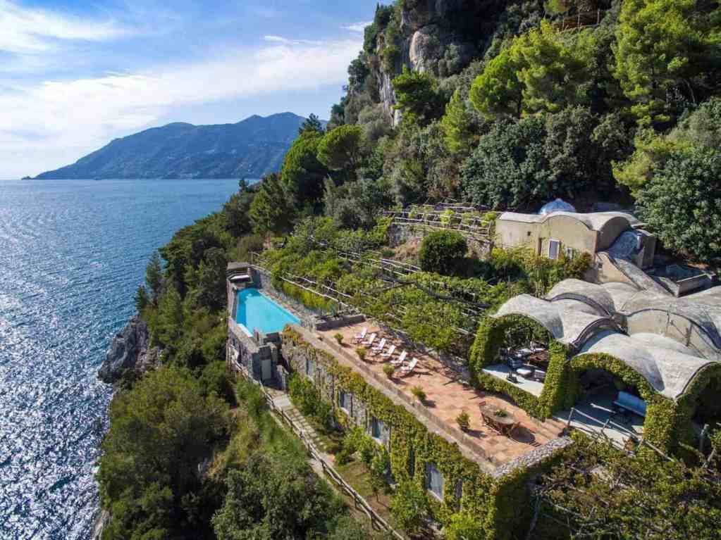 Scenic view of a luxury villa on a cliff overlooking the Amalfi Coast.