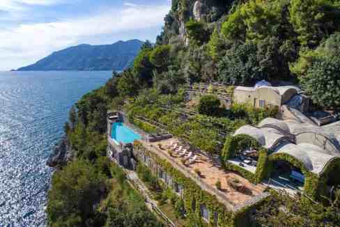 Scenic view of a luxury villa on a cliff overlooking the Amalfi Coast.