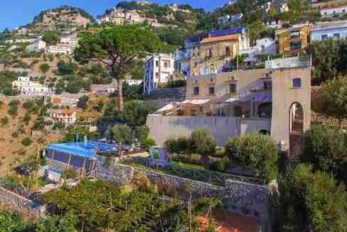 Coastal hillside villa with lush greenery and scenic ocean views in Nocerino.