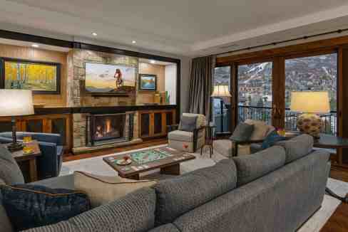 Elegant living room with fireplace, large windows, and mountain scenery.