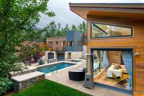 Contemporary serviced apartment with outdoor pool and lush greenery.