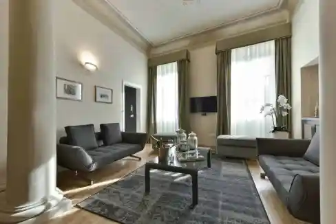 Stylish living room in a Florentine Palazzo with classic decor and large windows.