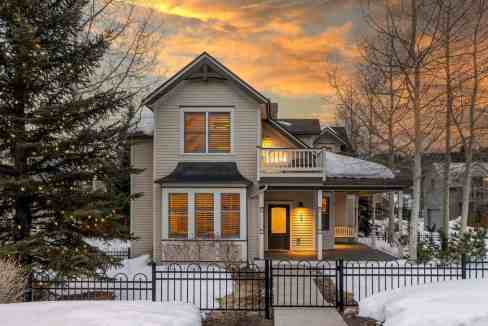Cozy snow-covered house with warm lights and winter landscape.