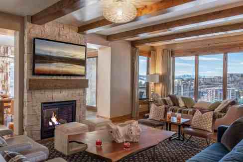Elegant living room with fireplace and panoramic city view from large windows.