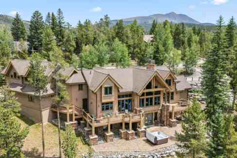 Spacious mountain chalet surrounded by tall pine trees and scenic mountain views.