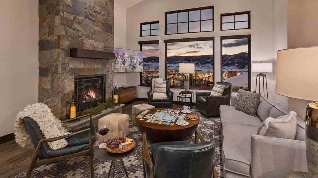 Elegant living room with large windows overlooking mountain landscape.