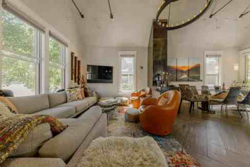 Bright living room with large windows, cozy sofa, and contemporary decor.