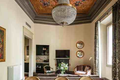Elegant living room with ornate ceiling, chandelier, and classic decor.