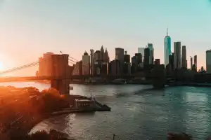 Sunset over Manhattan skyline with Brooklyn Bridge and East River.