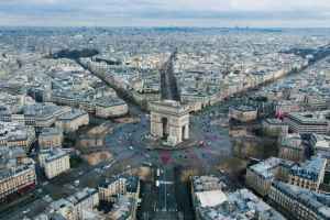 Aerial view of the Arc de Triomphe in Paris with surrounding cityscape.