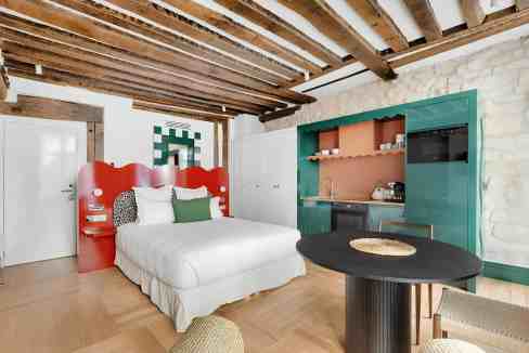 Charming studio with modern decor and rustic wooden ceiling.