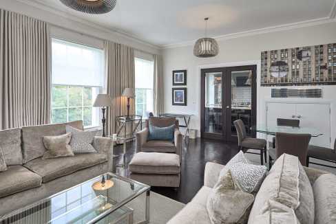 Spacious living room with large windows, modern furniture, and stylish decor.