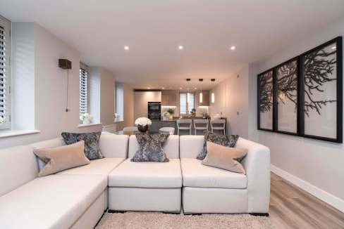 Bright, stylish living room with white sofa and black wall art.