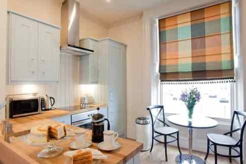 Bright kitchen with breakfast table and colorful window blind.