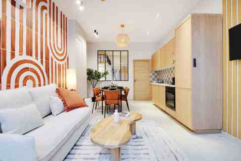 Stylish living room with modern decor and open kitchen in Montmartre.