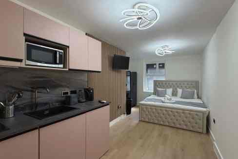 Contemporary bedroom and kitchenette in a serviced apartment.