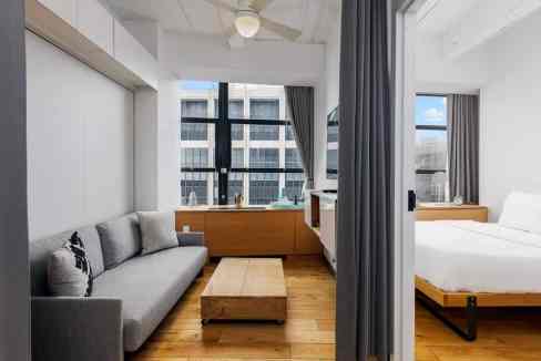 Bright, modern serviced apartment with living area and bedroom.