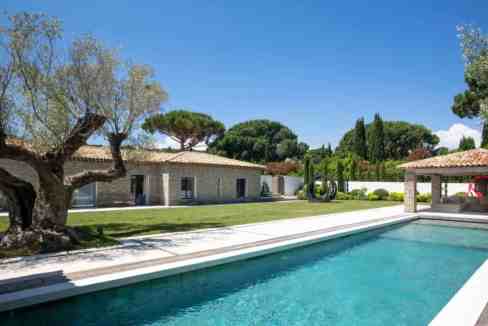 Elegant swimming pool with Mediterranean-style villas and lush greenery.
