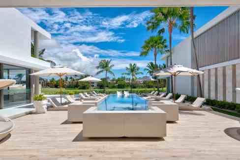Elegant poolside lounge with sunbeds and umbrellas at Punta Cana Royale.