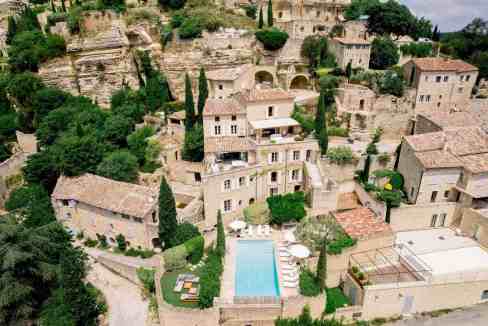 Luxury villa on a Provençal cliff with pool and lush greenery.