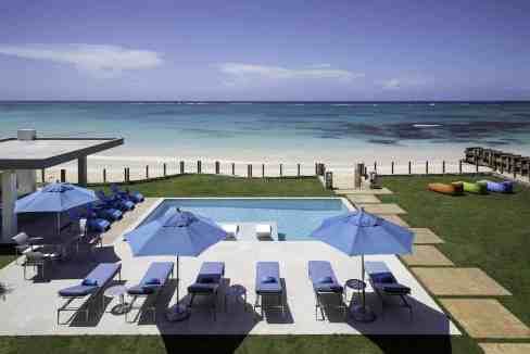 Elegant beachfront pool with sun loungers and umbrellas at Old Fort Bay Lido.