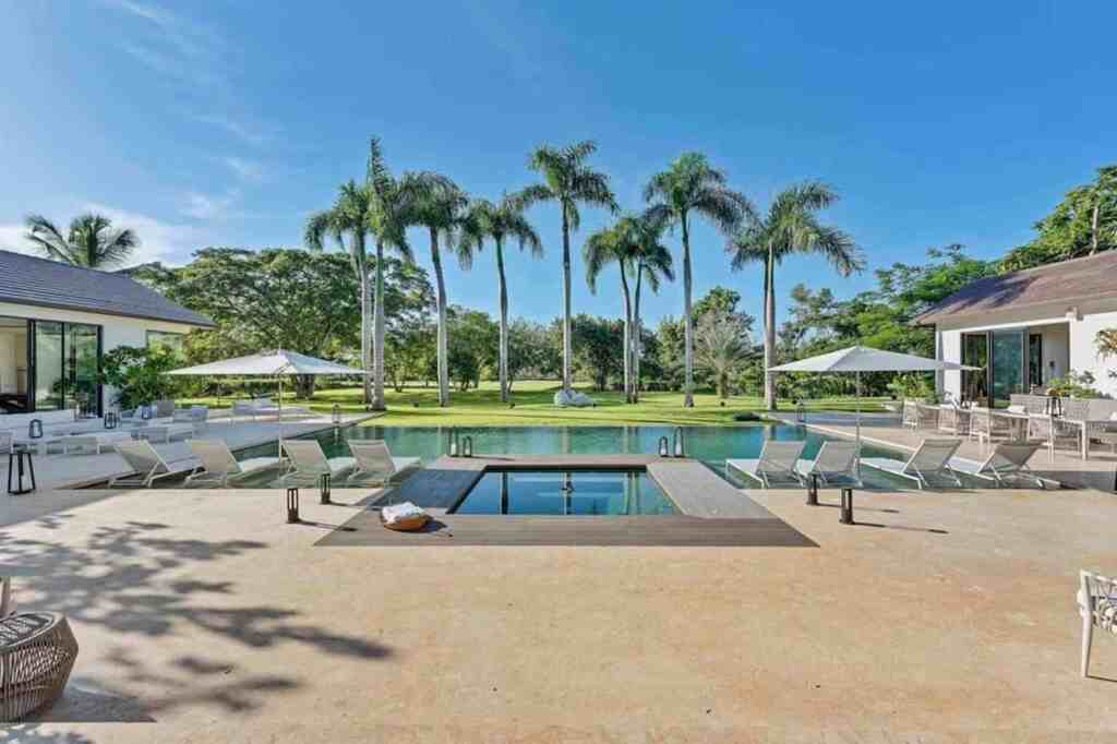 Elegant outdoor pool with palm trees and lounge chairs at Still Life Global.