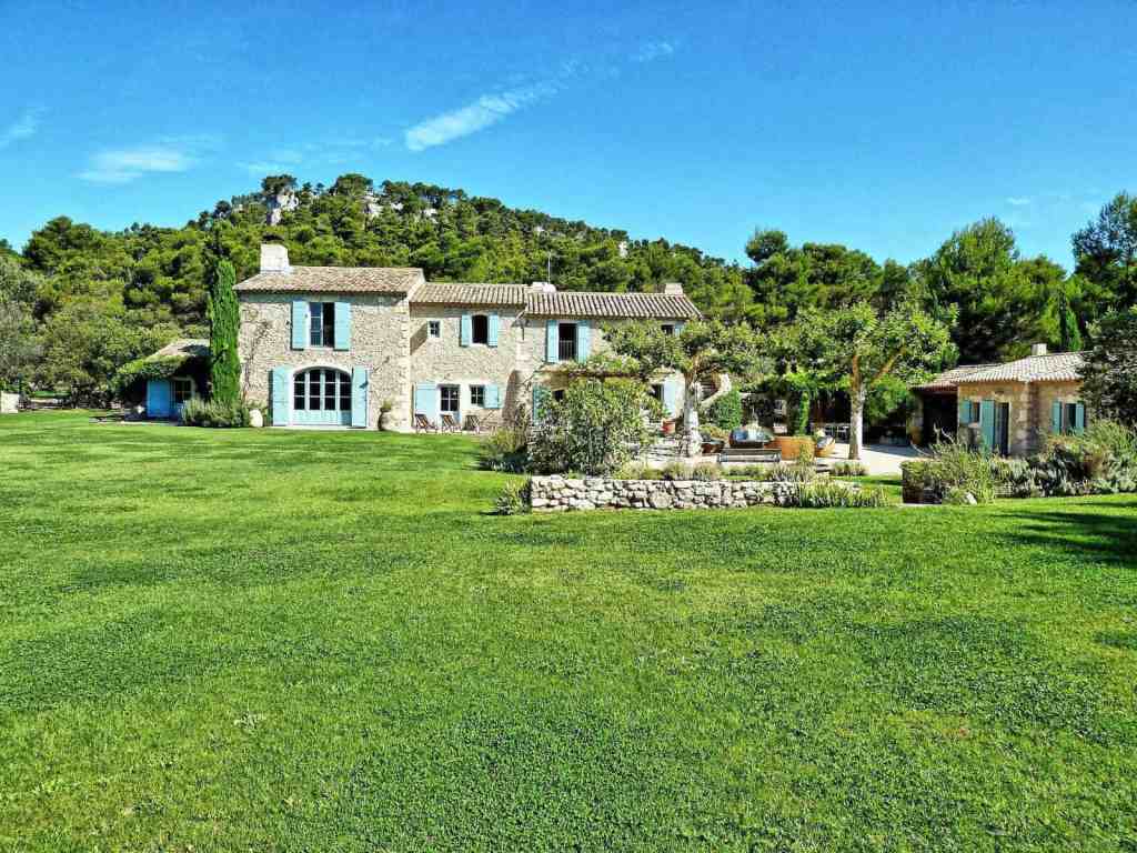 Beautiful Provençal-style estate with lush gardens and scenic hillside backdrop.