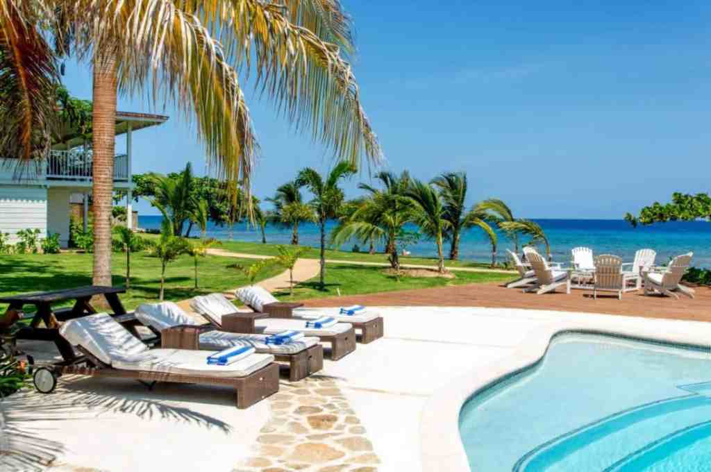 Poolside lounge chairs with ocean view at Runaway Bay Cove.