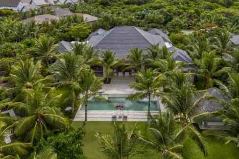Aerial view of a tropical villa with pool surrounded by palm trees in Punta Cana.