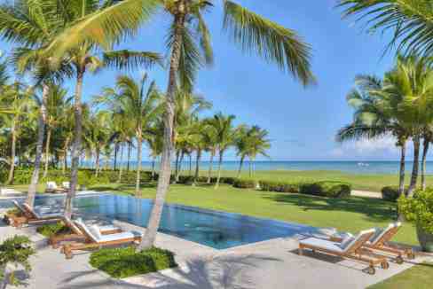 Luxury tropical poolside with palm trees and lounge chairs in Punta Cana.