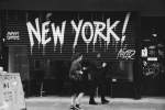 Street scene in New York with pedestrians and graffiti art.